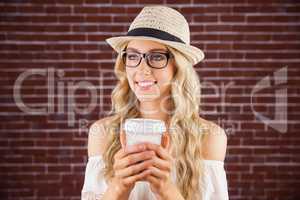 Gorgeous smiling blonde hipster holding take-away cup