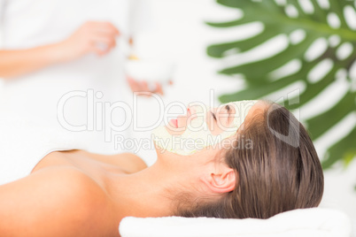 Attractive having white cream on her face at spa center