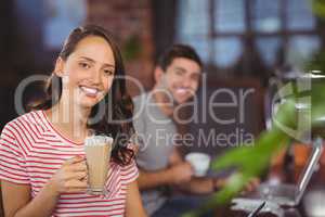 Smiling young woman with latte