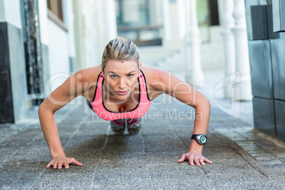 A pretty woman doing push-ups on the floor
