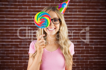 Portrait of a hipster hiding herself behind a lollipop