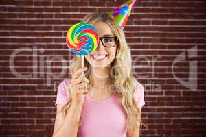 Portrait of a hipster hiding herself behind a lollipop