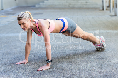 A pretty woman doing push-ups on the floor