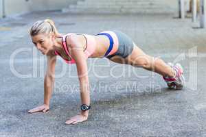 A pretty woman doing push-ups on the floor