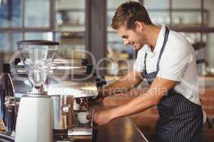 Handsome barista making a cup of coffee