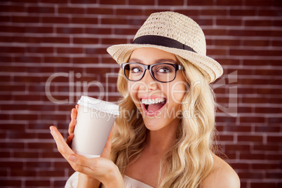 Gorgeous smiling blonde hipster presenting take-away cup