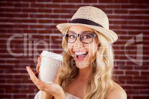 Gorgeous smiling blonde hipster presenting take-away cup