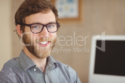 Happy hipster sitting at his desk