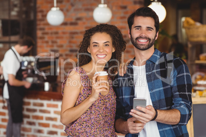 Smiling hipster couple holding smartphone
