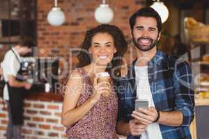 Smiling hipster couple holding smartphone