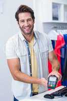 Smiling cashier showing credit card reader