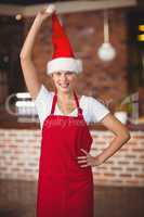 Pretty waitress touching her santa hat
