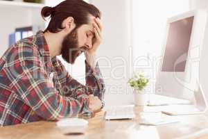 Hipster businessman stressed at his desk