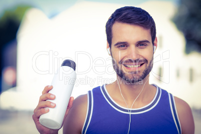 An handsome athlete holding a bottle