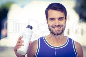 An handsome athlete holding a bottle