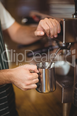 Barista steaming milk at the coffee machine