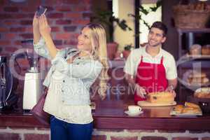 Pretty woman and waiter taking a selfie