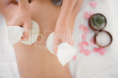 Pretty woman enjoying a herbal compress massage