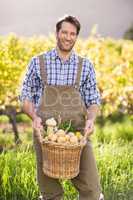 Smiling farmer holding a basket of potatoes