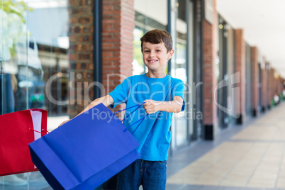 Young boy playing with shopping bags
