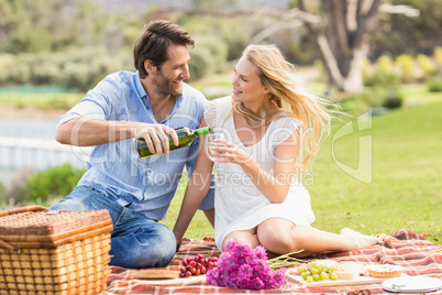 Cute couple on date pouring wine in a glass