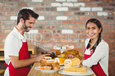 Waiters tidying up pastries on the counter