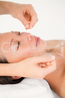 Hands threading beautiful womans face