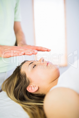 Close up view of relaxed pregnant woman getting reiki treatment