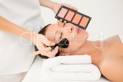 Hand applying makeup to beautiful woman
