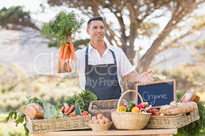 Smiling farmer holding a bunch of carrots