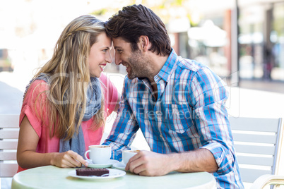 Cute couple sitting at a cafe head to head