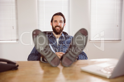 Hipster businessman relaxing at his desk