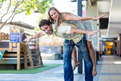 Smiling woman piggy-backing on her boyfriend