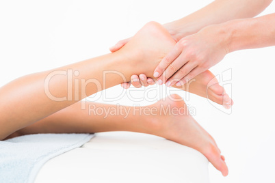 Woman receiving leg massage at spa center