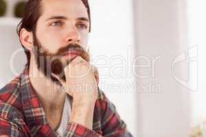 Hipster businessman thinking at his desk