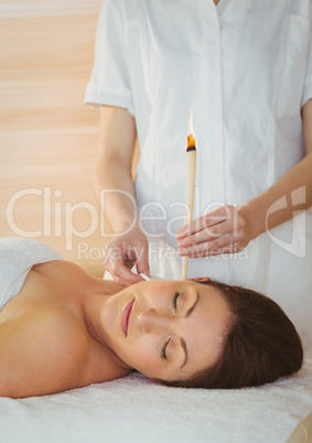 Young woman getting an ear candling treatment