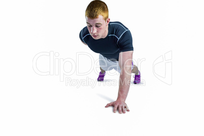 Muscular rugby player doing one hand push ups