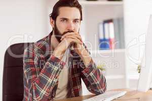 Hipster businessman sitting at his desk