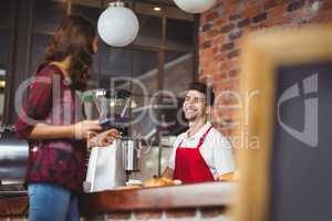 Handsome barista discussing with a customer