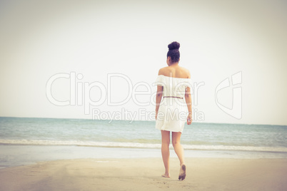 Stylish woman walking on the sand