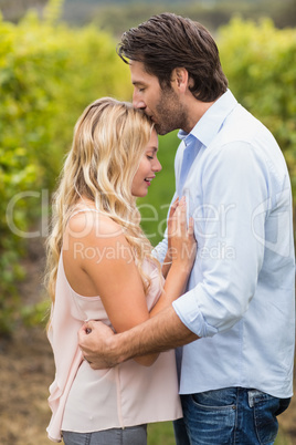 Young happy man kissing woman on the forehead