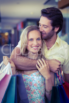 Smiling woman being kissed on forehead by her boyfriend