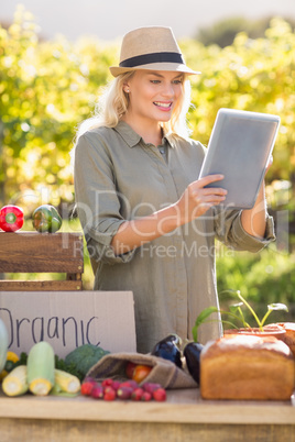 Smiling blonde farmer using a tablet