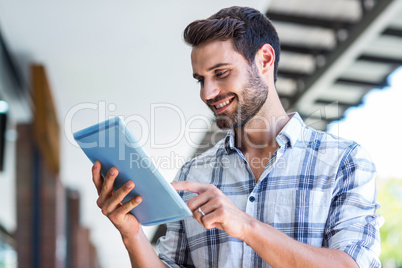 Hipster man using tablet computer in the city