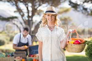 Blonde woman holding a vegetables basket
