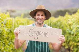 Young happy vintner holding an sign