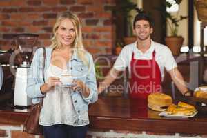 Smiling customer holding a cup of coffee