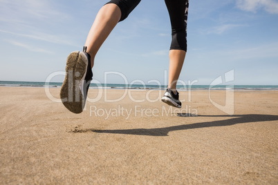 Fit woman jogging on the sand