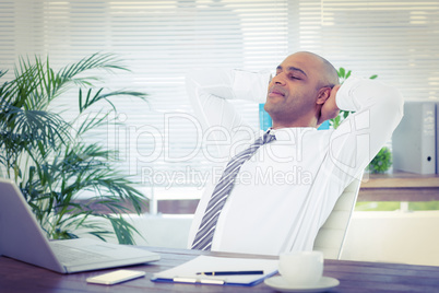 Relaxed businessman lying down in swivel chair