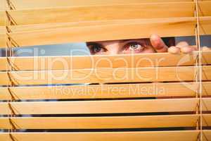 Hipster businessman peeking through blinds